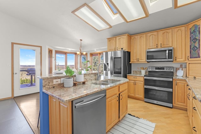 2301 Larkspur Ln, Great Falls, MT 59404 - kitchen with a center island with sink, a chandelier, light stone counters, a sink, and stainless steel appliances