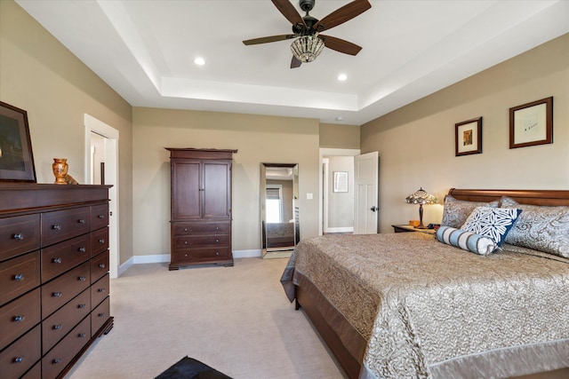 bedroom featuring recessed lighting, light colored carpet, and a raised ceiling