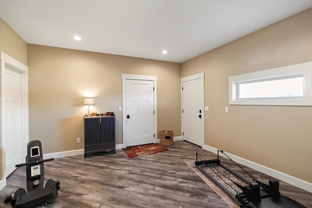 workout room featuring baseboards, recessed lighting, and wood finished floors