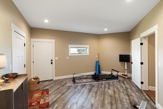 exercise area featuring baseboards, recessed lighting, and wood finished floors