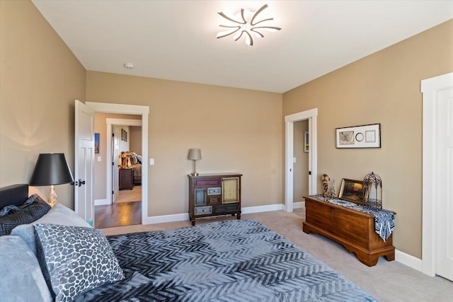 bedroom featuring baseboards and light carpet
