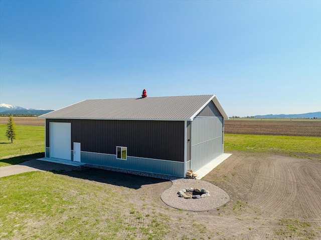 detached garage featuring a mountain view and a rural view