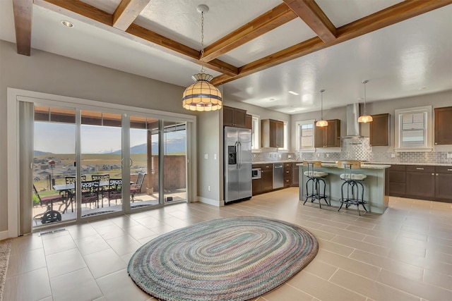 5010 Jeff Dr, Missoula, MT 59803 - kitchen with beam ceiling, a kitchen breakfast bar, wall chimney exhaust hood, tasteful backsplash, and appliances with stainless steel finishes