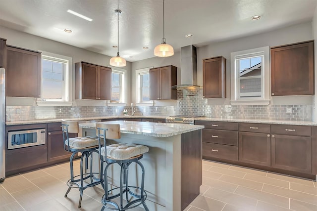 5010 Jeff Dr, Missoula, MT 59803 - kitchen with a breakfast bar, wall chimney range hood, a center island, built in microwave, and a sink