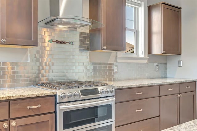 5010 Jeff Dr, Missoula, MT 59803 - kitchen featuring wall chimney range hood, stainless steel range with gas stovetop, backsplash, and light stone counters