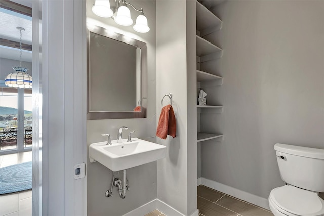 5010 Jeff Dr, Missoula, MT 59803 - bathroom with baseboards, toilet, and a notable chandelier