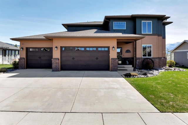 5010 Jeff Dr, Missoula, MT 59803 - prairie-style house featuring brick siding, an attached garage, driveway, and a front lawn