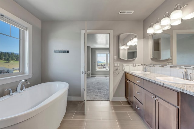 5010 Jeff Dr, Missoula, MT 59803 - bathroom featuring baseboards, a freestanding tub, visible vents, and a sink