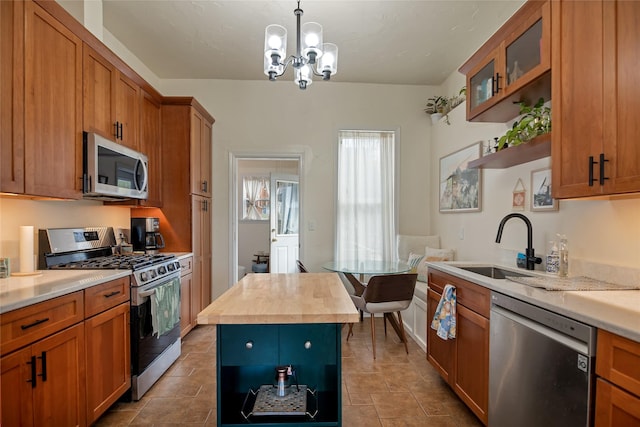kitchen featuring open shelves, appliances with stainless steel finishes, a sink, wood counters, and a chandelier