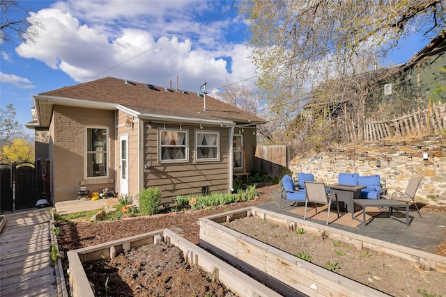 back of property with a patio, fence, a garden, and roof with shingles