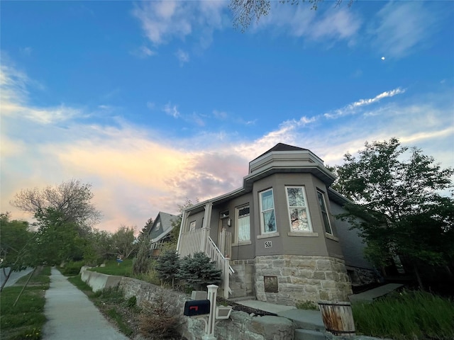 view of front of property featuring stairs and stone siding