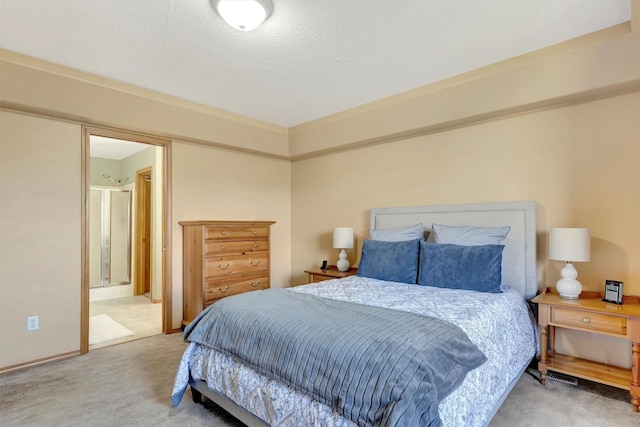 bedroom with light carpet and ensuite bath