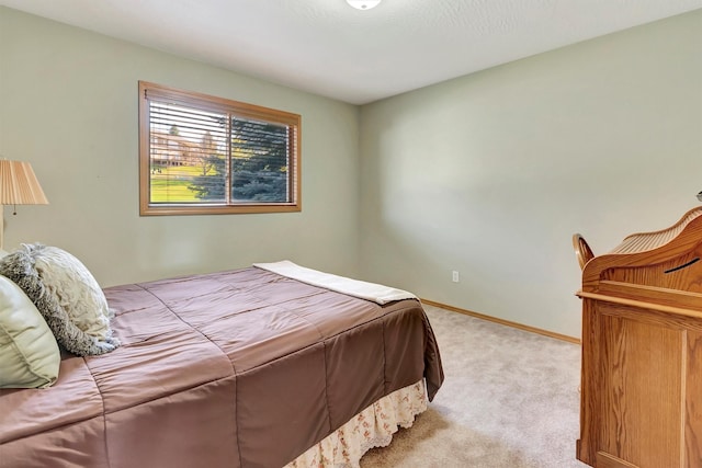 bedroom featuring baseboards and light carpet