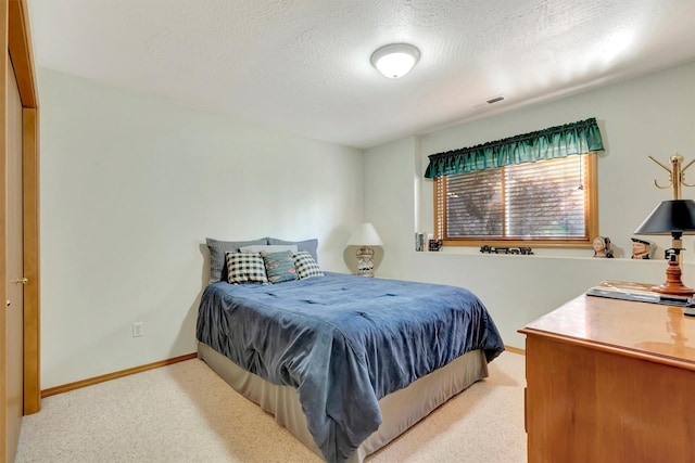 carpeted bedroom with a textured ceiling, baseboards, and visible vents