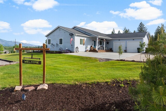 118 Rambling River Rd, Stevensville, MT 59870 - view of exterior entry featuring covered porch, roof with shingles, a garage, and concrete driveway