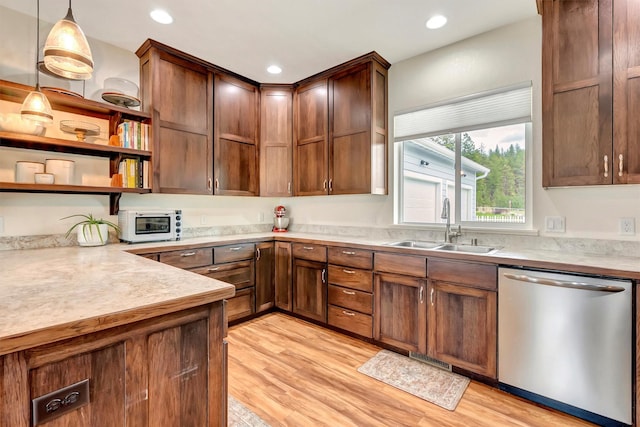 kitchen with stainless steel dishwasher, open shelves, light countertops, a sink, and light wood finished floors