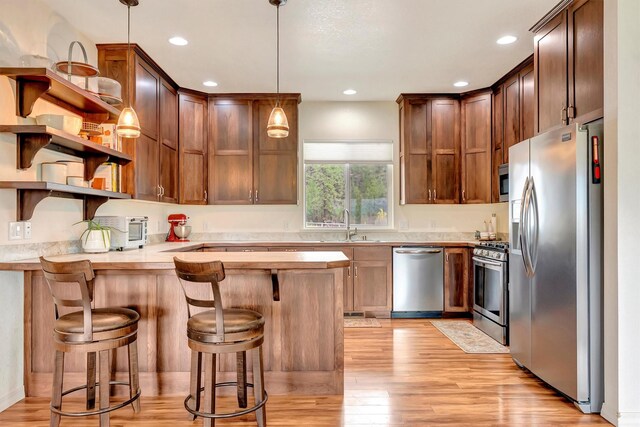 118 Rambling River Rd, Stevensville, MT 59870 - kitchen with stainless steel dishwasher, a sink, light wood-type flooring, light countertops, and open shelves