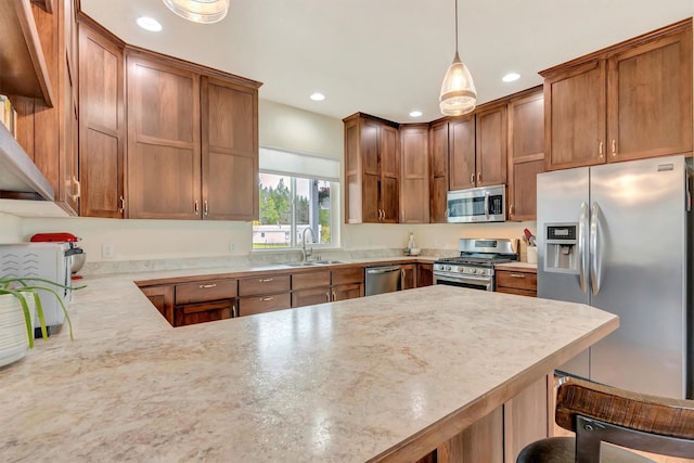kitchen with a kitchen bar, appliances with stainless steel finishes, a sink, a peninsula, and recessed lighting