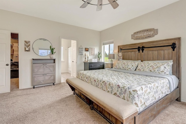 bedroom featuring a ceiling fan, a spacious closet, ensuite bathroom, and carpet