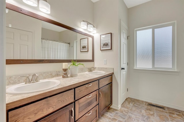 full bath featuring a sink, a healthy amount of sunlight, double vanity, and visible vents