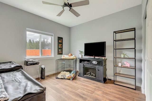 bedroom featuring light wood-style floors, baseboards, ceiling fan, and visible vents