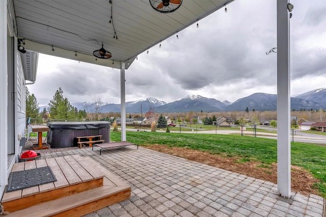view of patio with a mountain view and a hot tub