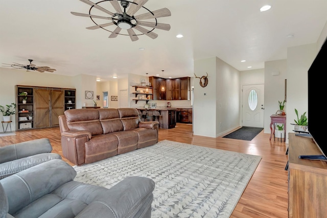 living room with recessed lighting, baseboards, a ceiling fan, and light wood-type flooring