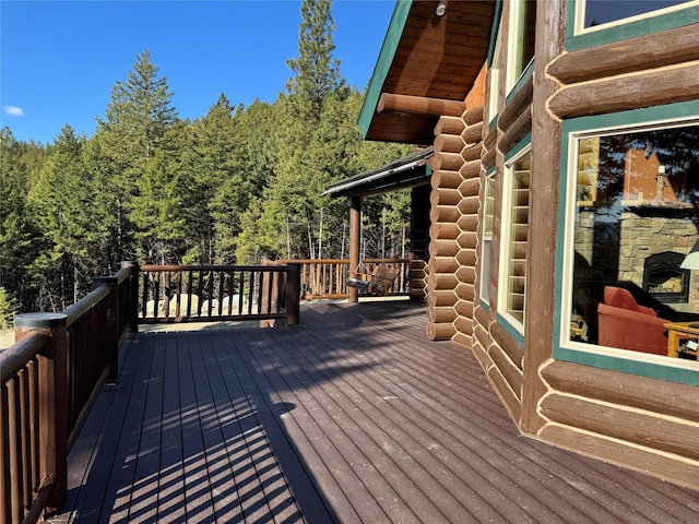 wooden terrace featuring a forest view