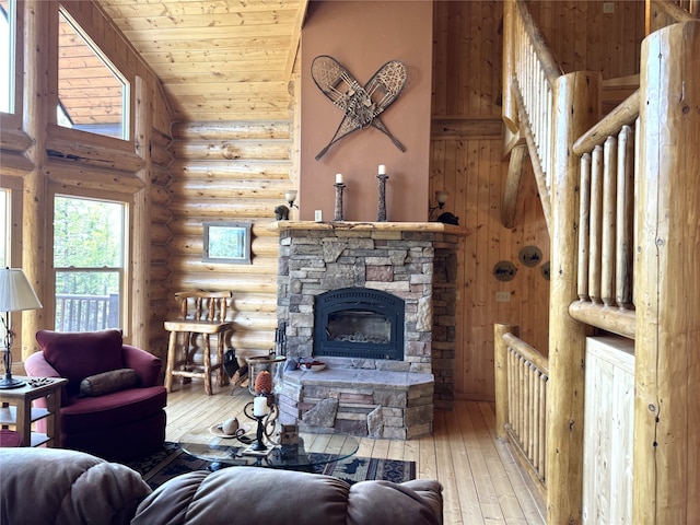 living room featuring a stone fireplace, hardwood / wood-style floors, wooden ceiling, rustic walls, and vaulted ceiling