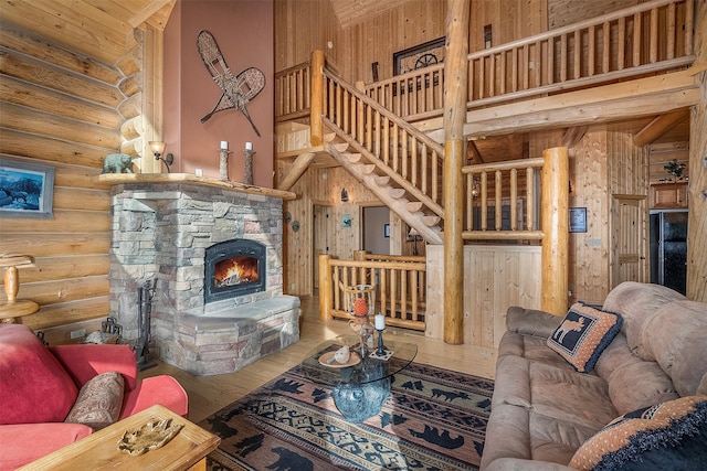 550 Jackson Meadows Rd, Kila, MT 59920 - living area featuring hardwood / wood-style floors, log walls, stairway, a stone fireplace, and a high ceiling