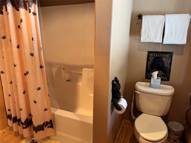 bathroom with toilet and shower / tub combo with curtain