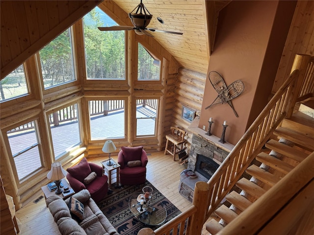 living area featuring log walls, high vaulted ceiling, hardwood / wood-style floors, and a wealth of natural light