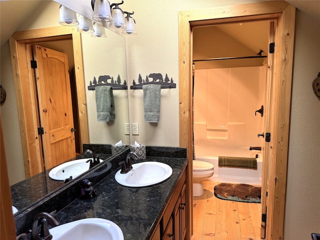 bathroom featuring a sink, wood finished floors, and shower / washtub combination