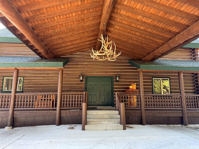 interior space with log exterior and a shingled roof