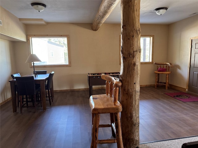 dining room with beamed ceiling, visible vents, plenty of natural light, and wood finished floors