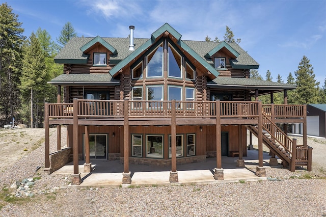 550 Jackson Meadows Rd, Kila, MT 59920 - rear view of house with log siding, a wooden deck, and roof with shingles