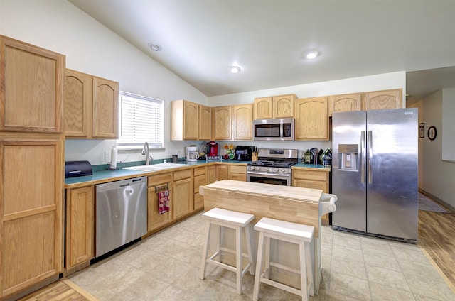 2603 Quinn Ct, Missoula, MT 59804 - kitchen with light brown cabinetry, vaulted ceiling, a sink, light countertops, and stainless steel appliances