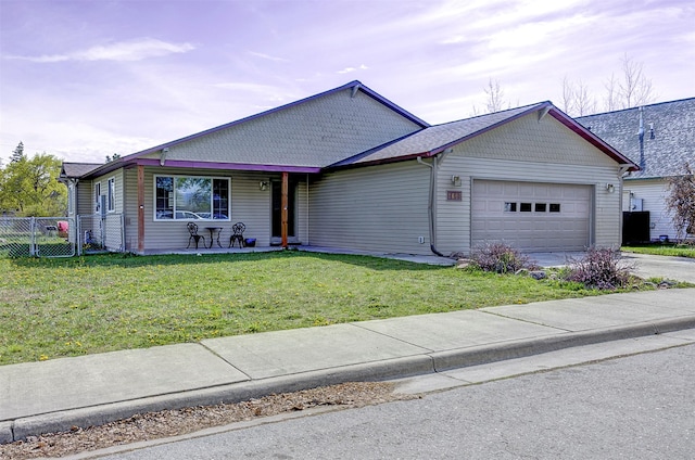 ranch-style house featuring driveway, fence, a front lawn, and a garage