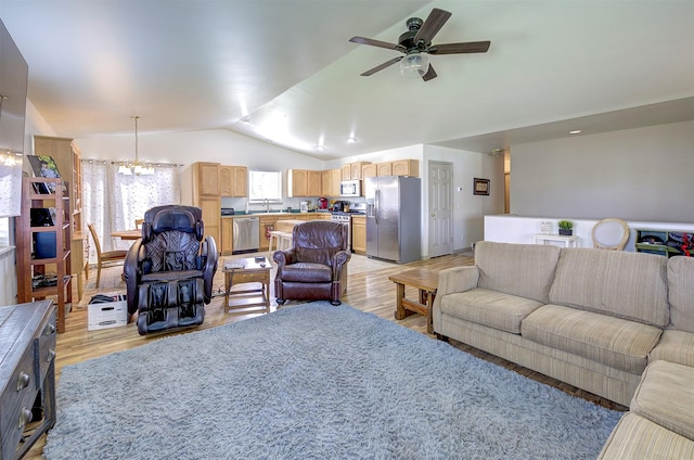living area with light wood-type flooring, ceiling fan with notable chandelier, and vaulted ceiling