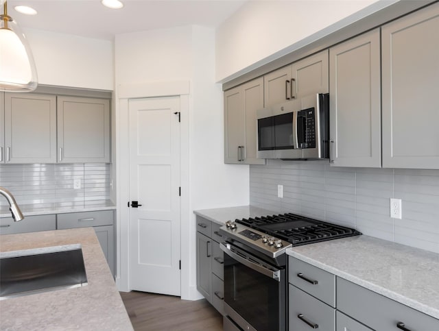 kitchen featuring appliances with stainless steel finishes, gray cabinetry, and tasteful backsplash