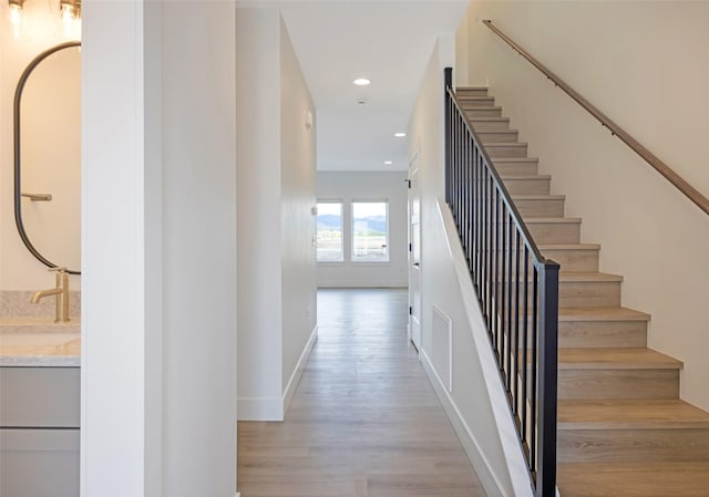 stairway with recessed lighting, baseboards, visible vents, and wood finished floors