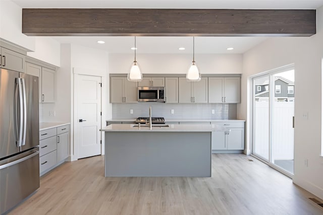 kitchen featuring decorative backsplash, gray cabinets, light wood finished floors, and stainless steel appliances