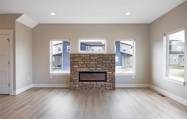 unfurnished living room featuring visible vents, a wealth of natural light, and wood finished floors