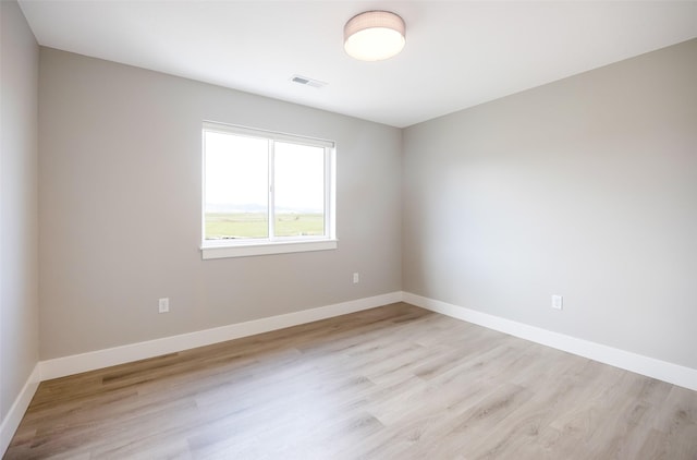 spare room with visible vents, baseboards, and light wood-type flooring
