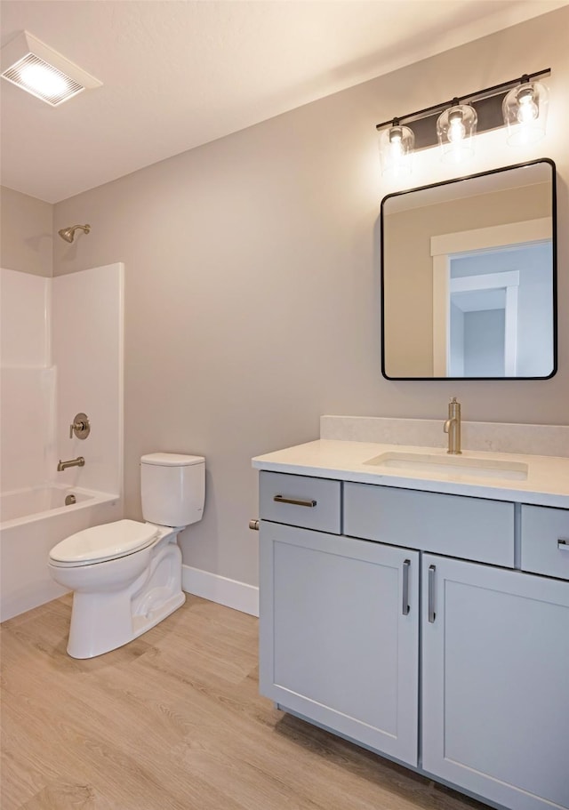 full bathroom with visible vents, vanity, wood finished floors, toilet, and baseboards