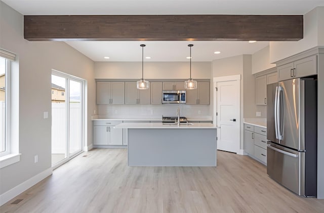 kitchen featuring decorative backsplash, beam ceiling, light countertops, gray cabinetry, and stainless steel appliances