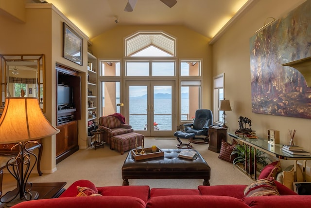 living area with carpet, ceiling fan, lofted ceiling, and a healthy amount of sunlight