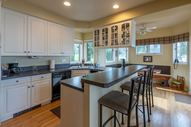 kitchen featuring a sink, dishwasher, a wealth of natural light, and a kitchen bar