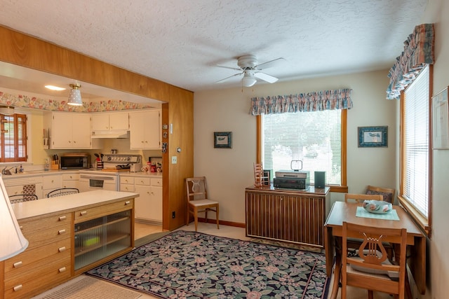 kitchen with ceiling fan, light countertops, a textured ceiling, stainless steel microwave, and white electric stove