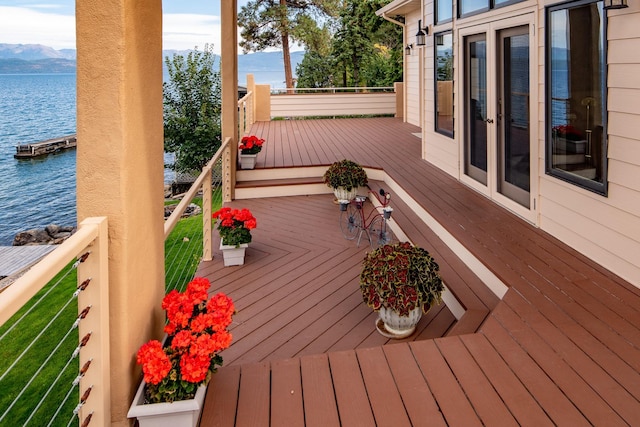 wooden deck with a water and mountain view
